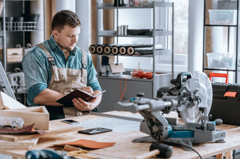Ein Handwerker ist in der Werkstatt dabei, Notizen zu machen 