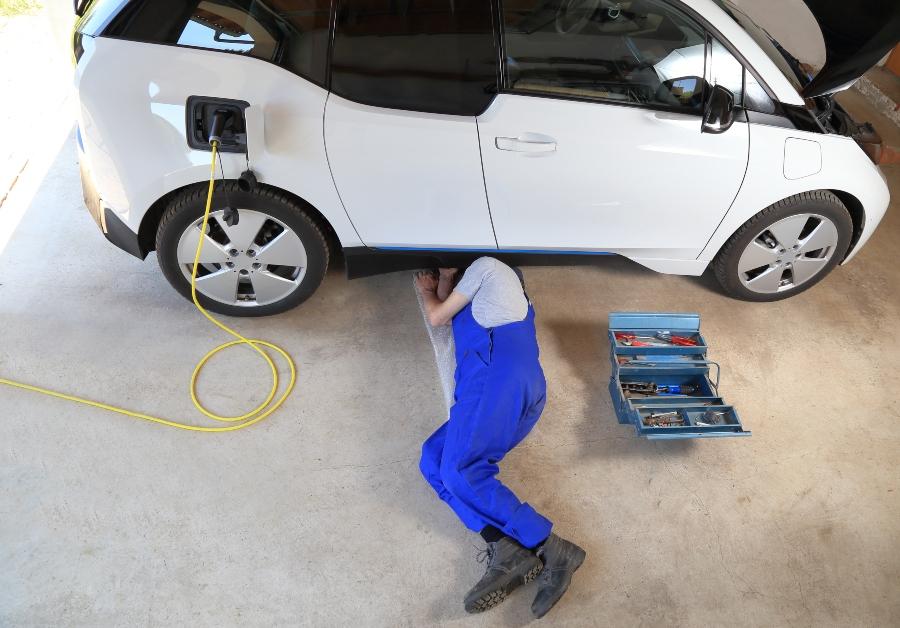 Mechaniker repariert Elektroauto elektroauto-werkstatt