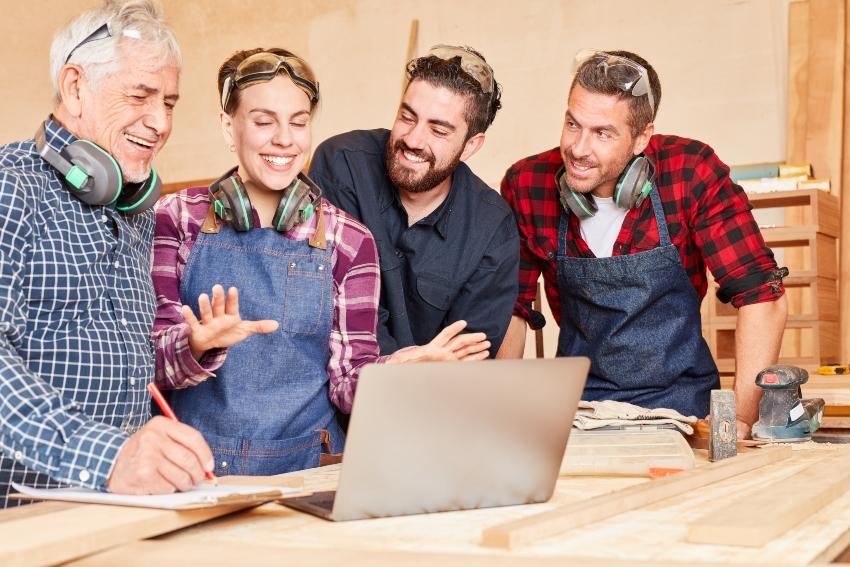 Gruppe von Handwerkern in einer Besprechung - Auftragsabwicklung im Handwerk