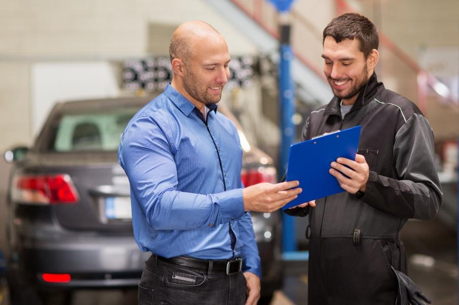 Automechaniker und Kunde im Autohaus kundenbeziehung-verbessern