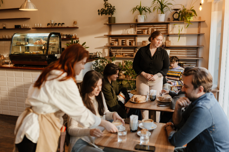 Angestellte in einem Café kommunizieren aktiv mit den Kunden 