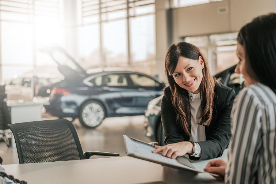 Autohaus-Marketing: Verläuferin zeigt Vertrag