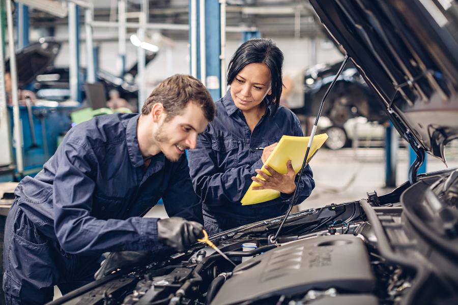 2 Mechaniker besprechen etwas zu einem Automotor