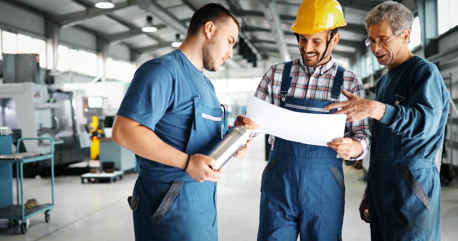 3 Handwerker besprechen eine Skizze oder ähnliches Dokument