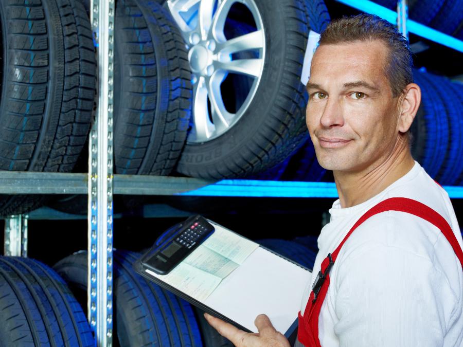 Mechaniker beim EInlagern von Reifen - Service Reifeneinlagerung und Räderwechsel