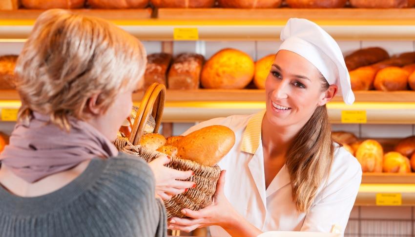 Junge Frau kauft in der Bäckerei ein - Stammkunden gewinnen und halten