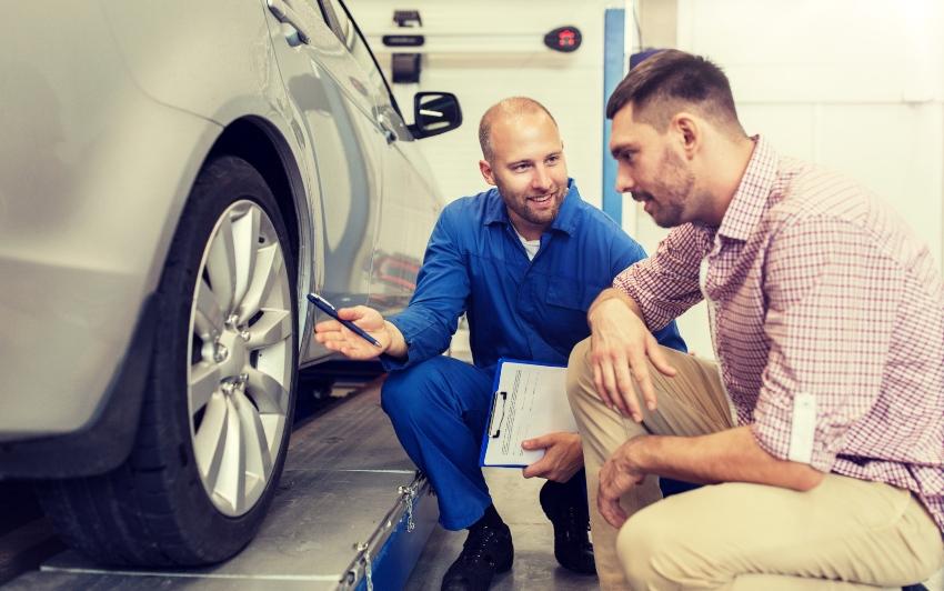 Mechaniker berät Kunden bezüglich der Reifen - Reifenwechsel Angebot