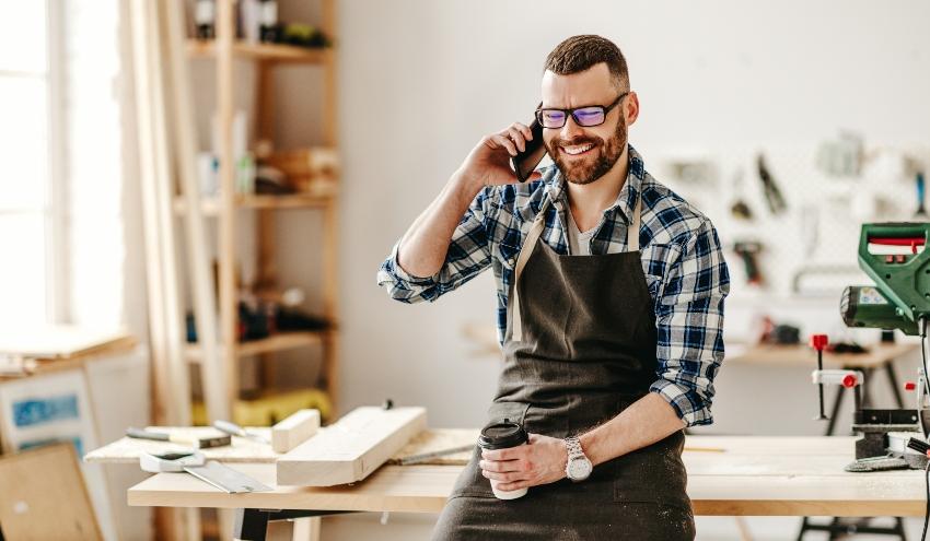 Junger Handwerker telefoniert