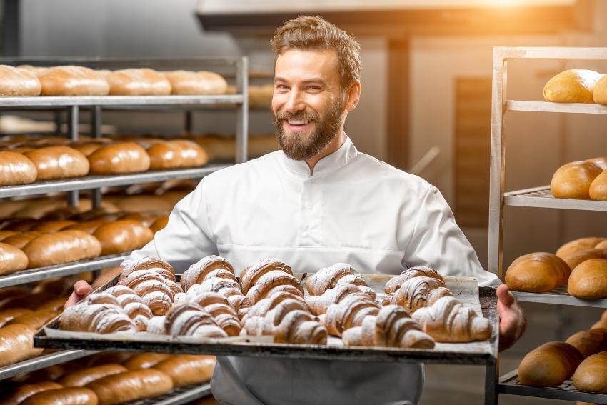 Fröhlicher Bäcker mit Zimtschnecken