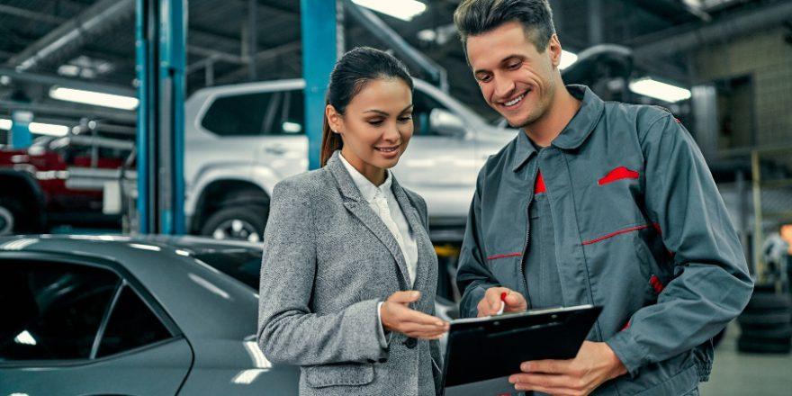 Junge Dame beim Auto-Mechaniker - Werkstattservice verbessern