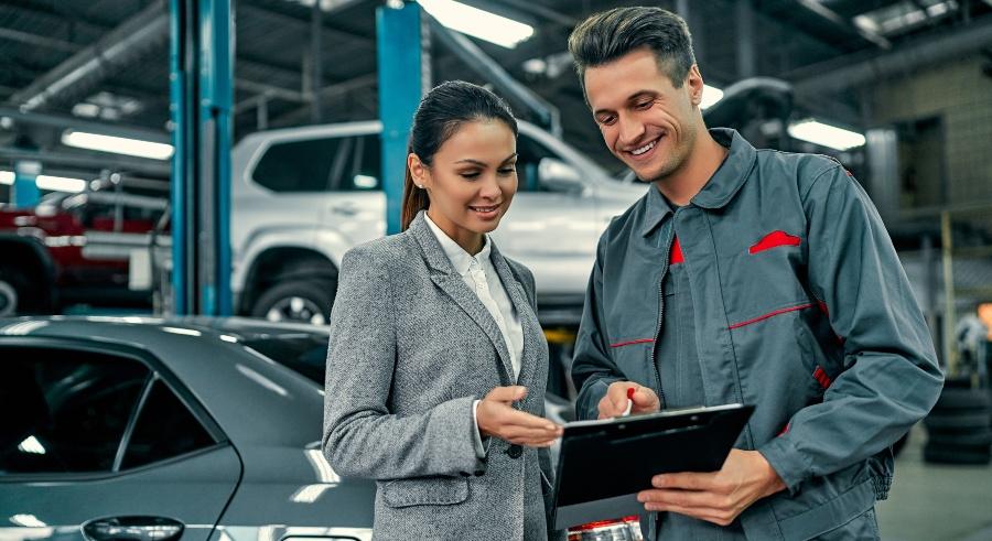 Junge Dame beim Auto-Mechaniker - Werkstattservice verbessern
