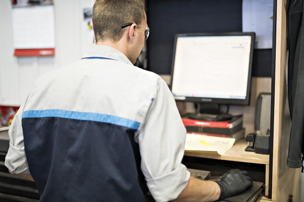 Handwerker sitzt am Computer