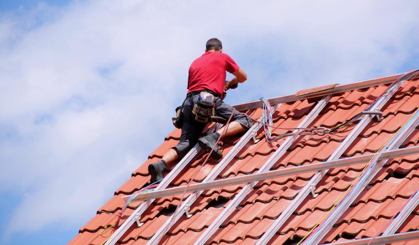 Dachdecker, gesichert, bei der Arbeit - Unfallverhütungsvorschriften in Deutschland