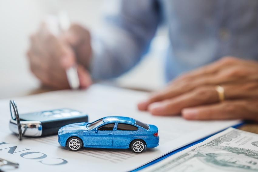 Mann unterschreibt Vertrag für Autokauf - Der gewerbliche Kaufvertrag für Autos