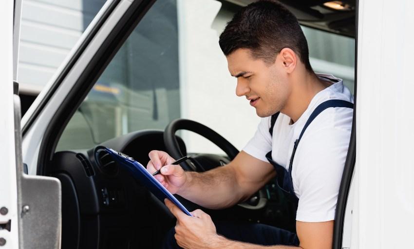 Mann im LKW füllt Fahrtenbuchvorlagen aus