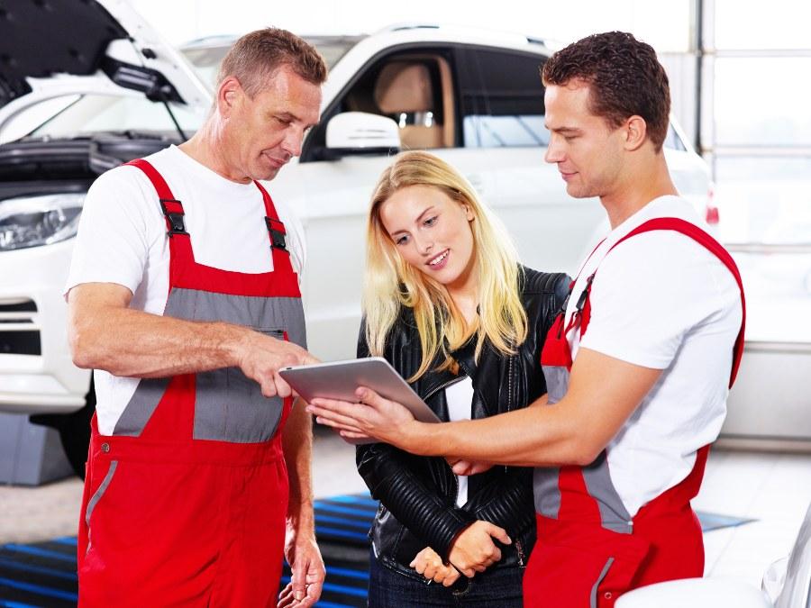 Gute Organisation und transparente Kommunikation erfreuen die Kunden Kundin im Gespräch mit 2 Mechanikern