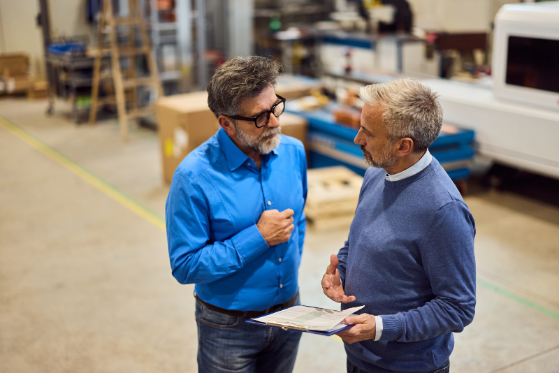 Ein Gespräch unter Kollegen in einem Werkstattumfeld