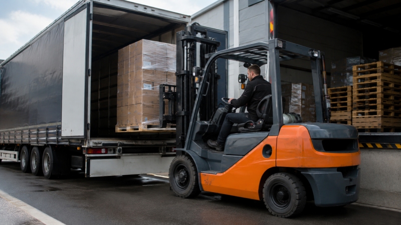 Gegengewichtsstapler beim Beladen eines Lkw Gegengewichtsstapler nimmt eine Palette direkt am Lkw auf und belädt den Auflieger